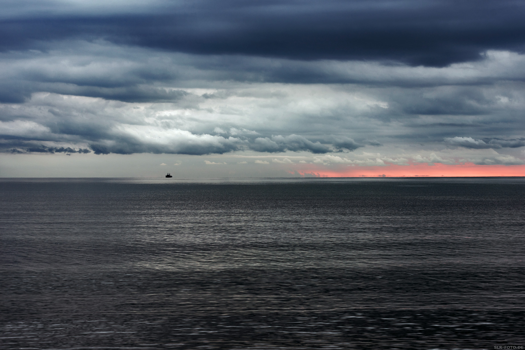 Ostsee bei Sonnenaufgang mit Schiff und Wolken